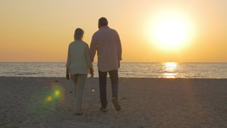Senior-couple-embracing-by-the-sea-at-sunset