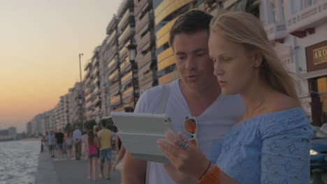 Couple-watching-tablet-at-the-beach