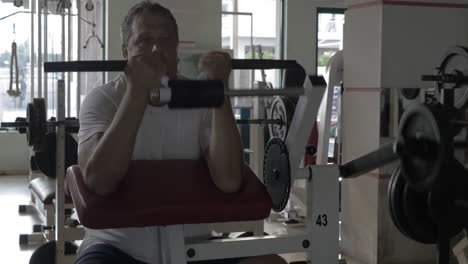 Senior-man-exercising-on-bicep-training-machine