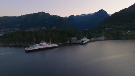 Drone-view-of-ferries-docked-at-Dragsvik-ferry-slip-on-Sognefjord,-Balestrand