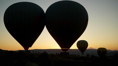 Eearly-morning-sunrise-flight-silhouetted-hot-air-balloons-take-off