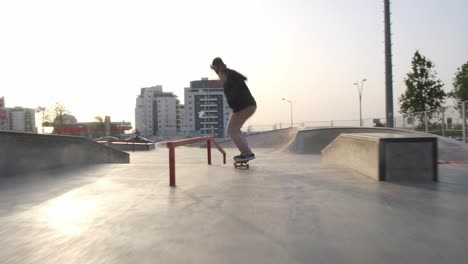 A-young-and-professional-skater-performing-skateboard-tricks-at-sunset-in-tourist-spot-skatepark-at-sunset