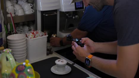 Videofilmer-Dreht-Ein-Video-Von-Einem-Barmann,-Der-Mit-Der-Stabilisierten-Kleinen-Mobilen-Kamera-DJI-Osmo-Pocket-3-Kaffee-Und-Cappuccino-Zubereitet