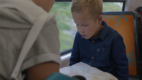 Boy-with-mom-looking-at-map-in-train