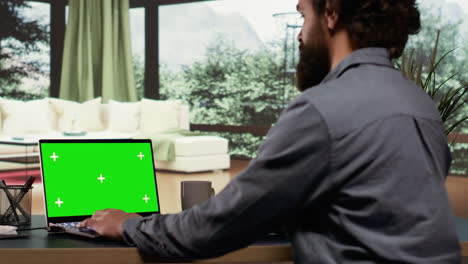 Businessman-looks-at-greenscreen-template-on-pc
