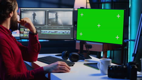 Videographer-splicing-film-pieces,-editing-them-using-professional-software-on-mockup-computer