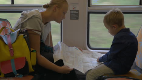 Mother-and-child-with-map-traveling-by-train
