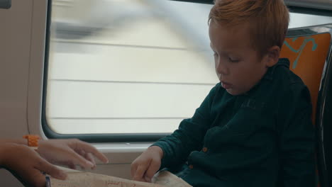 Child-looking-at-map-in-the-train