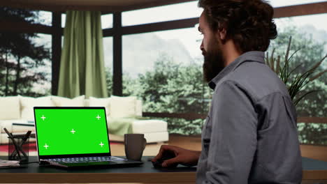 Young-millionaire-checks-greenscreen-template-on-laptop