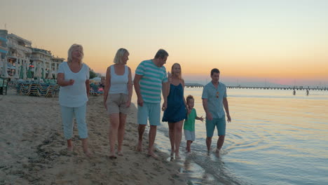 Große,-Glückliche,-Lustige-Familienspaziergänge-Am-Strand-Am-Meer,-Sonnenuntergang-Im-Hintergrund,-Piräus,-Griechenland