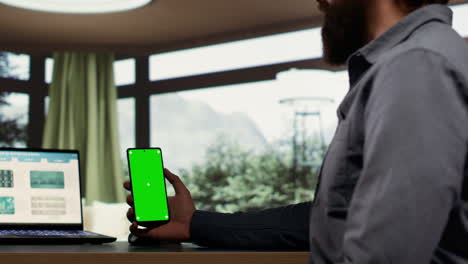 Entrepreneur-holding-smartphone-with-greenscreen-template