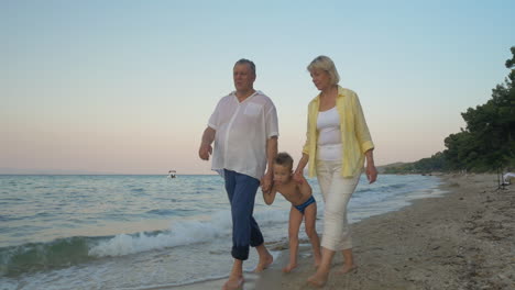 Großeltern-Und-Enkelkind-Gehen-Am-Strand-Spazieren