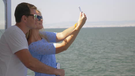 On-sea-in-city-of-Perea-Greece-on-a-ship-young-couple-doing-selfie-on-a-mobile-phone