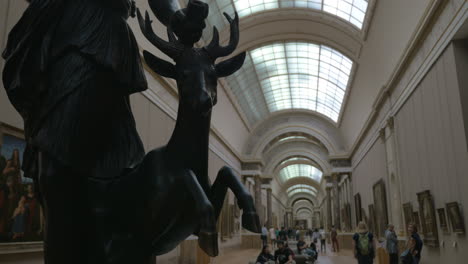 Visitors-in-the-Louvre-hall-with-paintings-and-sculptures