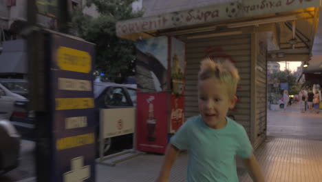 Niño-Corre-Por-Una-Concurrida-Calle-De-Tesalónica,-Grecia