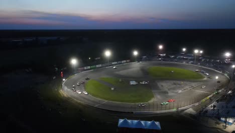 Bright-lamps-lit-race-track-during-race,-aerial-drone-view