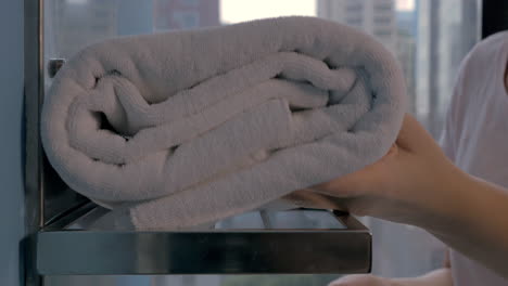Housekeeper-placing-bath-towels-in-hotel-bathroom