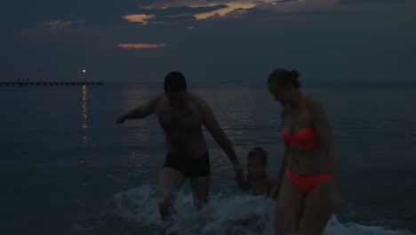 Familie-Schwimmt-Nach-Sonnenuntergang-Im-Meer,-Piräus,-Griechenland