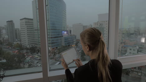 Businesswoman-with-pad-looking-at-Seoul-panorama-South-Korea