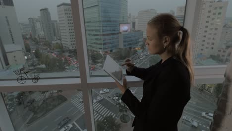 Geschäftsfrau-Mit-Touchpad-Am-Fenster-Mit-Seouler-Stadtbild,-Südkorea