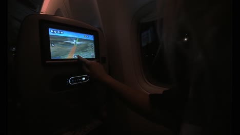 Frau-Benutzt-Nachts-Sitzmonitor-Im-Flugzeug