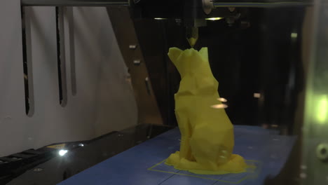 3D-printer-making-a-wolf-from-yellow-plastic