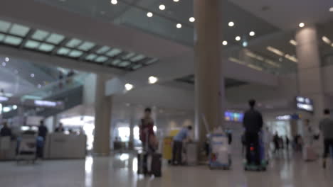 Menschen-Mit-Gepäck-Und-Wagen-Im-Flughafenterminal
