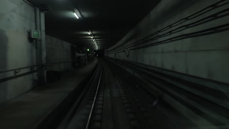 Vista-De-La-Cabina-Del-Tren-Moviéndose-En-El-Oscuro-Túnel-Del-Metro.