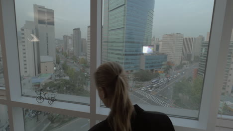 Woman-working-on-business-with-pad-by-window-with-Seoul-view-South-Korea