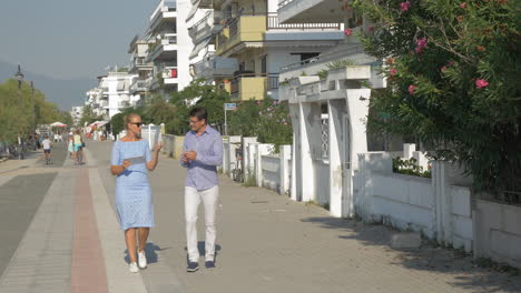 Junge-Frau-Und-Mann-Gehen-Tanzen-Und-Benutzen-Tablet-Auf-Der-Straße-In-Thessaloniki,-Griechenland