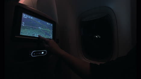 Woman-looking-at-plane-route-on-seat-monitor