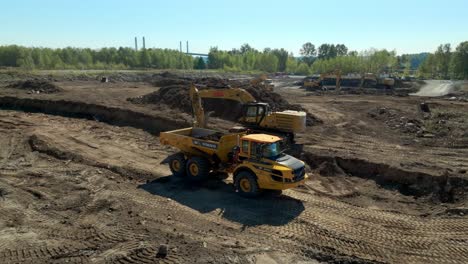 Excavator-Loading-Dump-Truck-With-Excavated-Soil-In-Preparation-for-Construction-Site