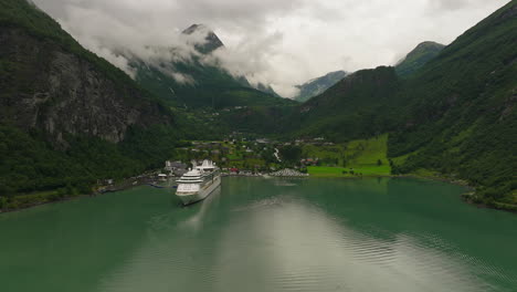 Scenic-Geiranger-fjord-with-docked-cruise-ship-at-tourist-village,-Norway