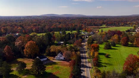 Eine-Luftaufnahme-Aus-Einem-Hohen-Winkel-über-Die-Ruhige-Landschaft-Von-New-Jersey-Mit-Bunten-Bäumen-Und-Großen-Grünen-Feldern-Rundherum-An-Einem-Sonnigen-Herbsttag