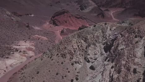 Drone-shot-revealing-Rainbow-Valley-red-sandstone-mountains-and-wild-deserted-terrain,-San-Pedro-de-Atacama-Desert-Chile,-Atacama-Desert,-Bolivia