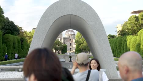 Hiroshima-Victims-Memorial-Cenotaph-With-Flame-Of-Peace-And-Atomic-Bomb-Dome-In-Background