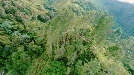 Drone-flight-over-green-mountains-in-jungle-with-Salto-del-Rodeo-Waterfall,-Dominican-Republic