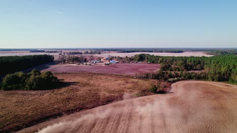 Aerial-view-of-a-harvester-on-a-Georgia-farmland,-plowing-through-the-fields-during-soybean-harvest-season