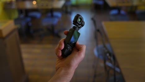 Hand-swiping-on-screen-of-DJI-Osmo-Pocket-3-stabilized-handheld-mobile-camera