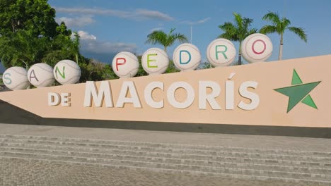 Zoom-out-shot-of-San-Pedro-De-Macoris-Logo-in-city-beside-highway-during-sunset-time