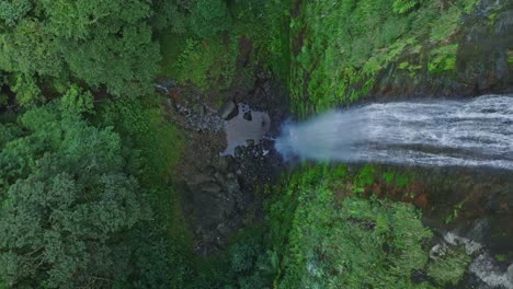 Rising-top-down-shot-of-epic-waterfall-crashing-down-into-jungle-of-Dominican-Republic---Salto-del-Rodeo,-Bonao