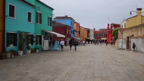 People-on-Burano-street-walking,-shopping-and-sightseeing-colourful-houses,-Venice,-Italy