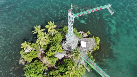 An-aerial-drone-shot-of-Octopus-Islet-Ecological-Adventure-Park-in-Bacuag,-Philippines-on-a-bright-day-with-crystal-clear-turquoise-ocean-all-around