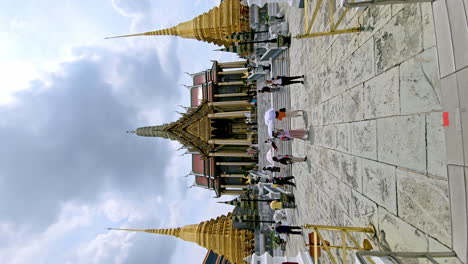 Vertical-shot-of-a-Buddhist-temple-filled-with-local-and-foreign-worshippers-and-tourists-in-Bangkok-Thailand