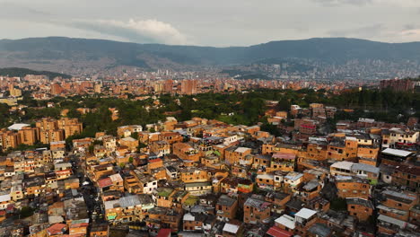 Drone-shot-over-the-sunlit-Comuna-13-district,-evening-in-Medellín,-Colombia
