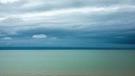 Zeitrafferaufnahmen-Eines-Strandes-Mit-Klarem,-Blauem-Wasser-Und-Ziehenden-Wolken-Darüber