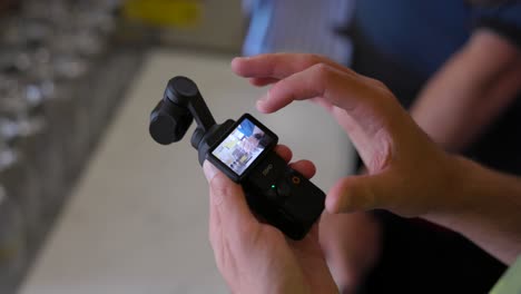 Hand-Auf-Der-Stabilisierten-Mobilen-Handkamera-DJI-Osmo-Pocket-3-Mit-Beleuchtetem-Bildschirm