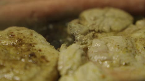 Close-up-view-of-some-smelt-cutlets-and-sausages-frying-in-a-pan