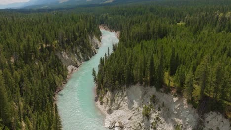 Drone-shot-of-the-Kootenay-River-in-British-Columbia-Canada,-panning-up-to-reveal-the-mountains-and-landscape