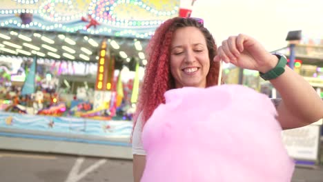 happy-woman-plays-with-cotton-candy-at-the-fair